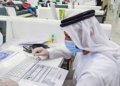 Archival photograph of a Sharjah government employee using a computer; not a photograph of the AWS memorandum signing