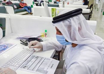 Archival photograph of a Sharjah government employee using a computer; not a photograph of the AWS memorandum signing