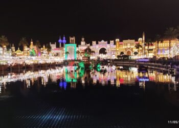 Illuminated Global Village Dubai pavilions reflected in water at night, archival 2023 photograph