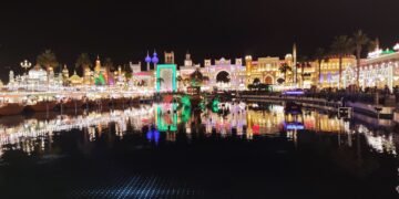 Illuminated Global Village Dubai pavilions reflected in water at night, archival 2023 photograph