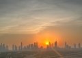Dubai skyline and Burj Khalifa silhouetted against the setting sun