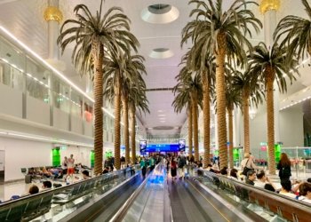 Dubai airport terminal moving walkway with passengers, illustrating Dubai visit visa travel