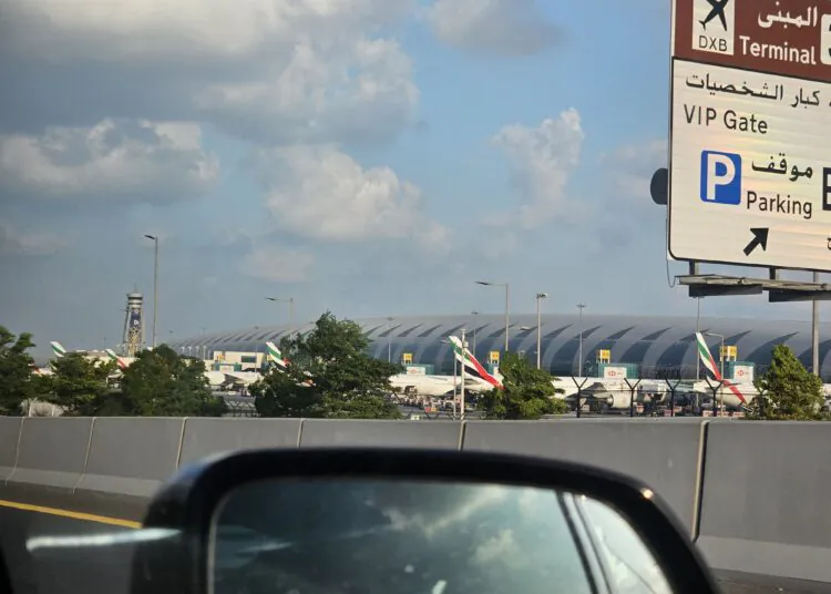 Emirates passenger aircraft parked at Dubai International Airport, UAE, under a partly cloudy sky; archival photograph, not depicting October 2026 conditions